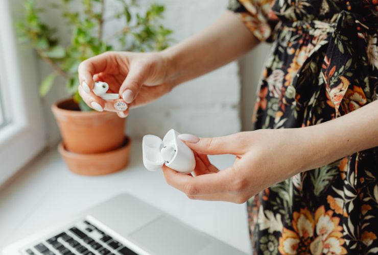 donna con airpods in mano e custodia