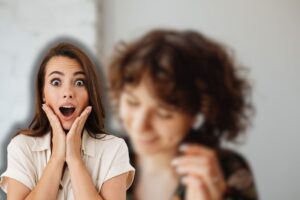 donna che usa airpods e un'altra sorpresa con mani in faccia